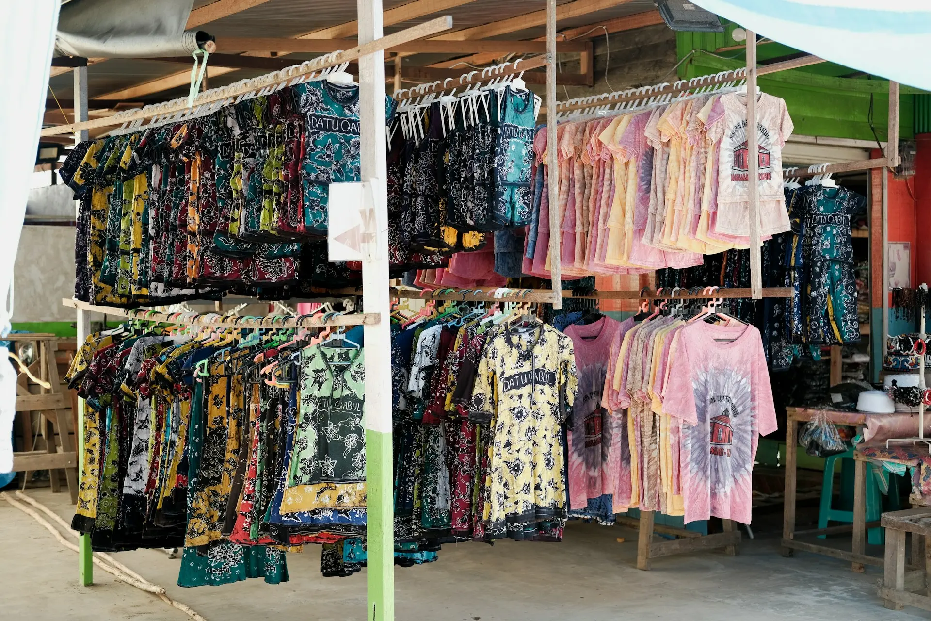 a woman is looking at a display of shirts
